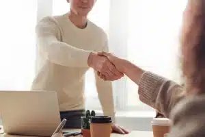 two persons shaking hands in the office