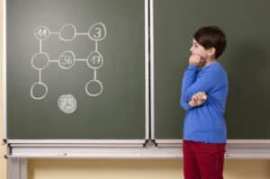 a boy solving the task on the blackboard