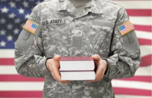 a soldier in uniform holding books in his hands