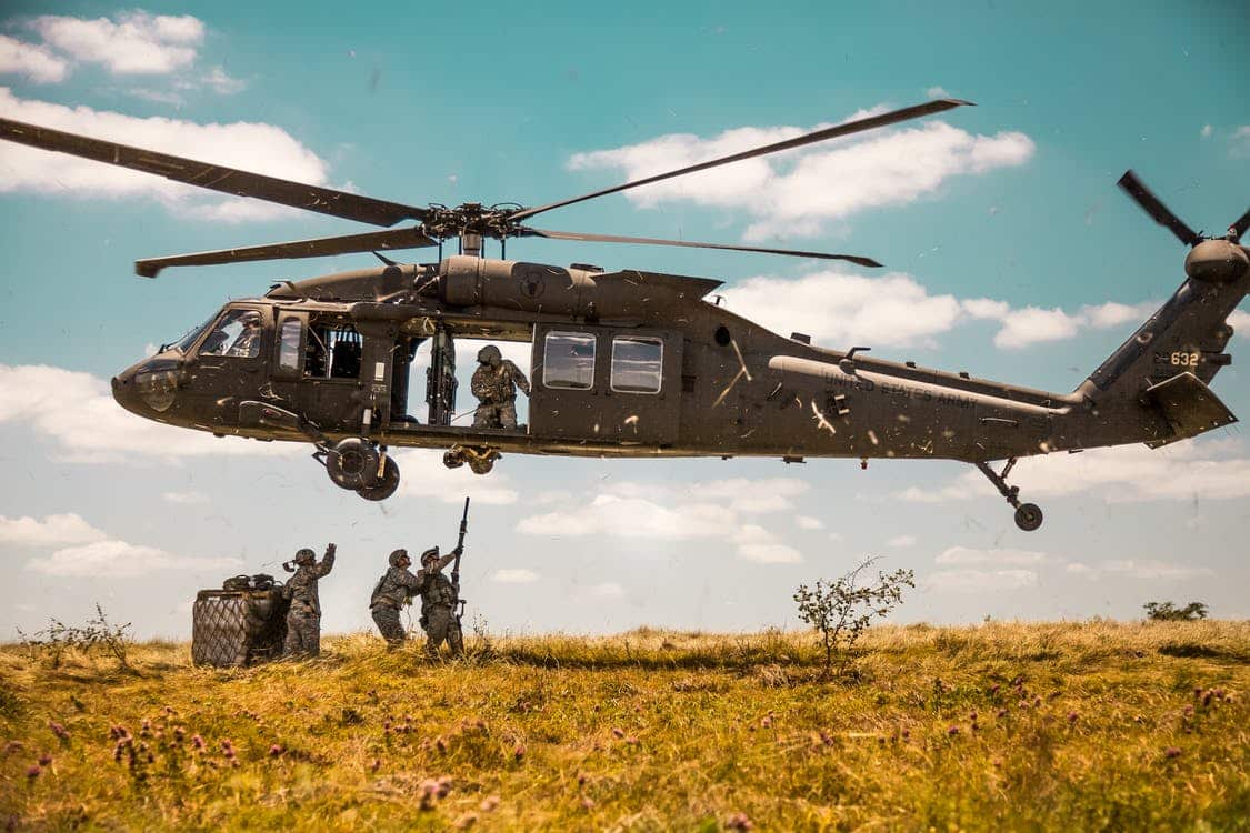 a group of soldiers under the helicopter in the air