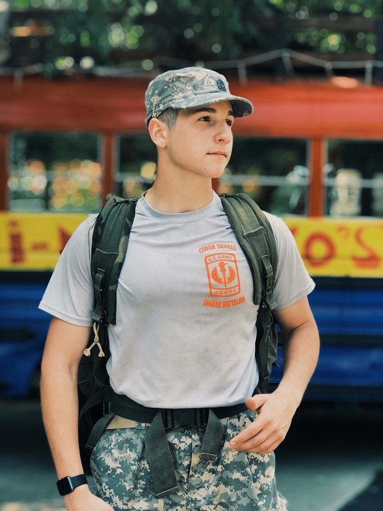Young boy Wearing Military Uniform Carrying a Backpack