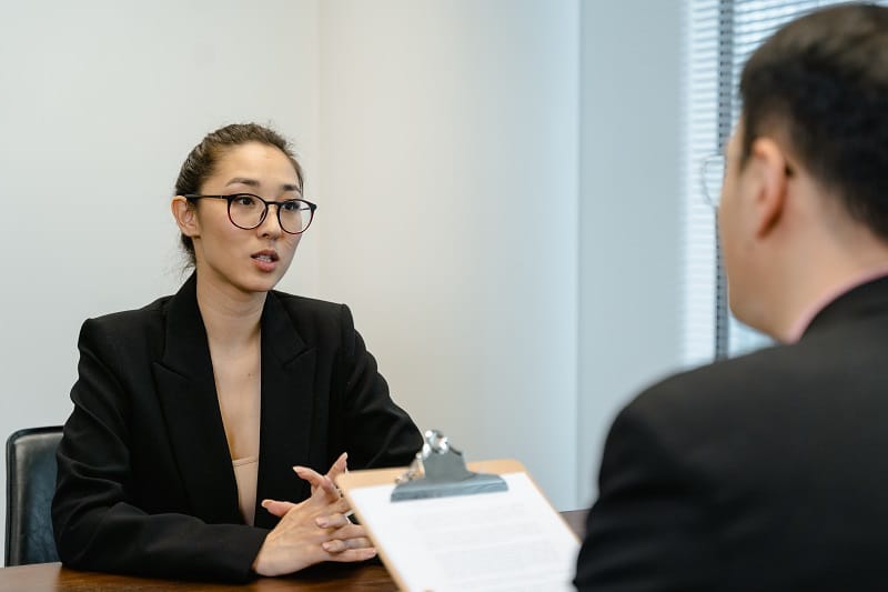 A Woman in Business Attire Talking To an Employer