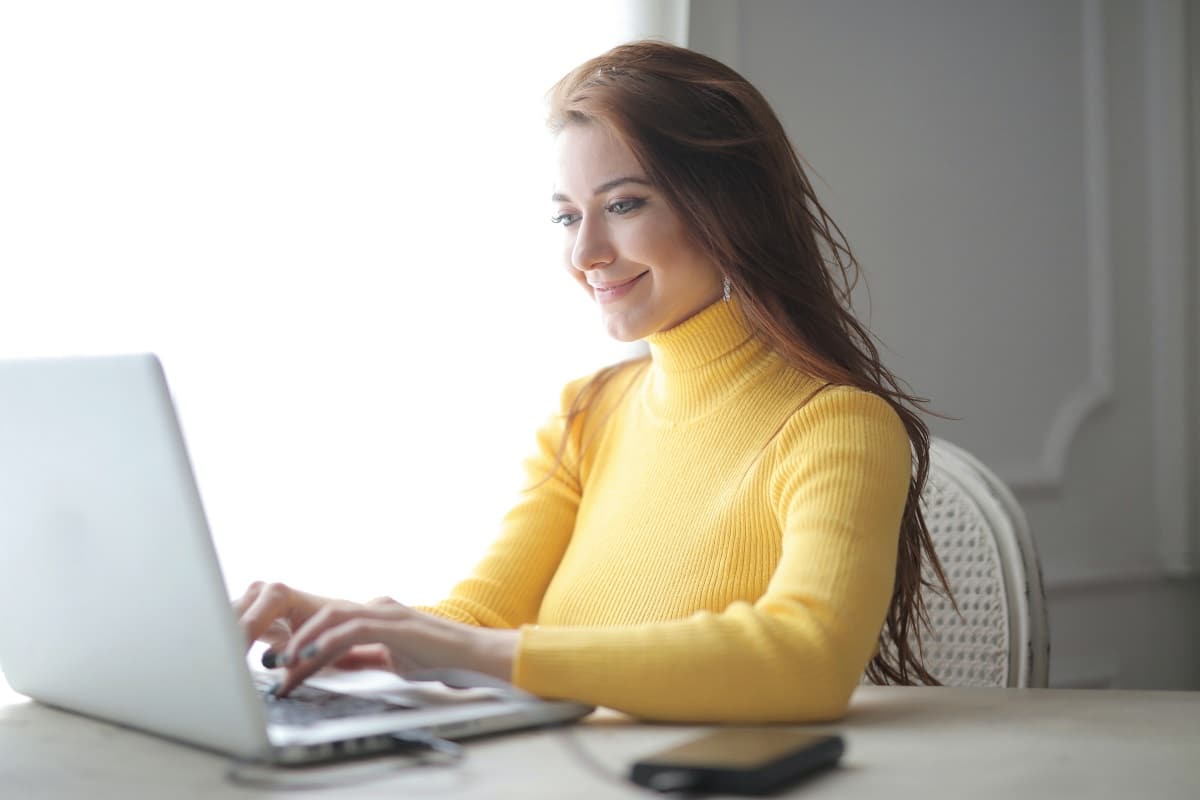Woman in Yellow Turtleneck Sweater Using Laptop